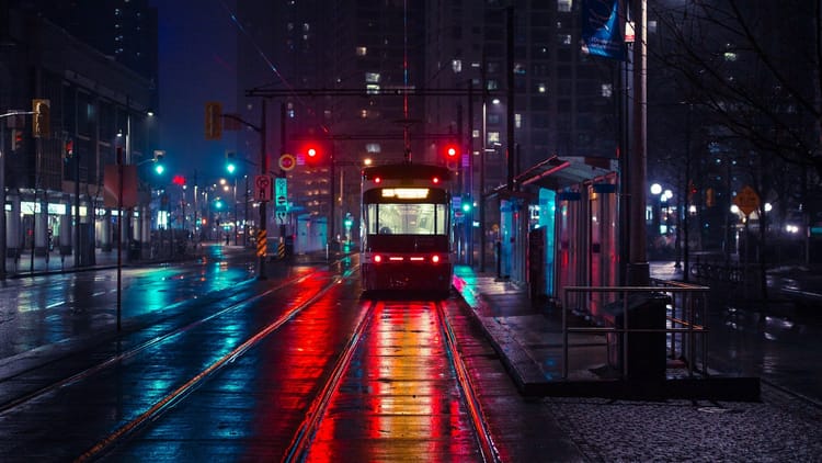 public transport in a dark urban area with city lights in the distance
