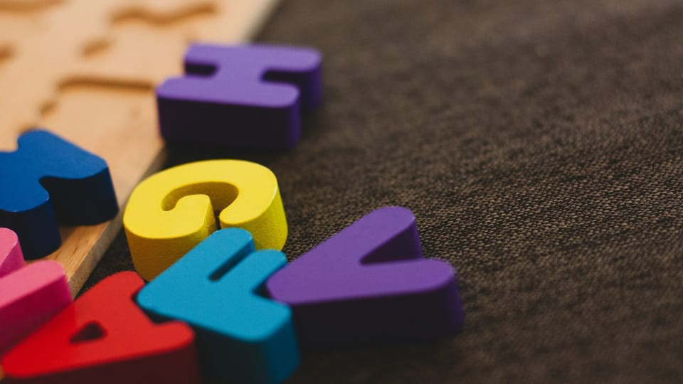 close-up of some colorful alphabet blocks on a carpet