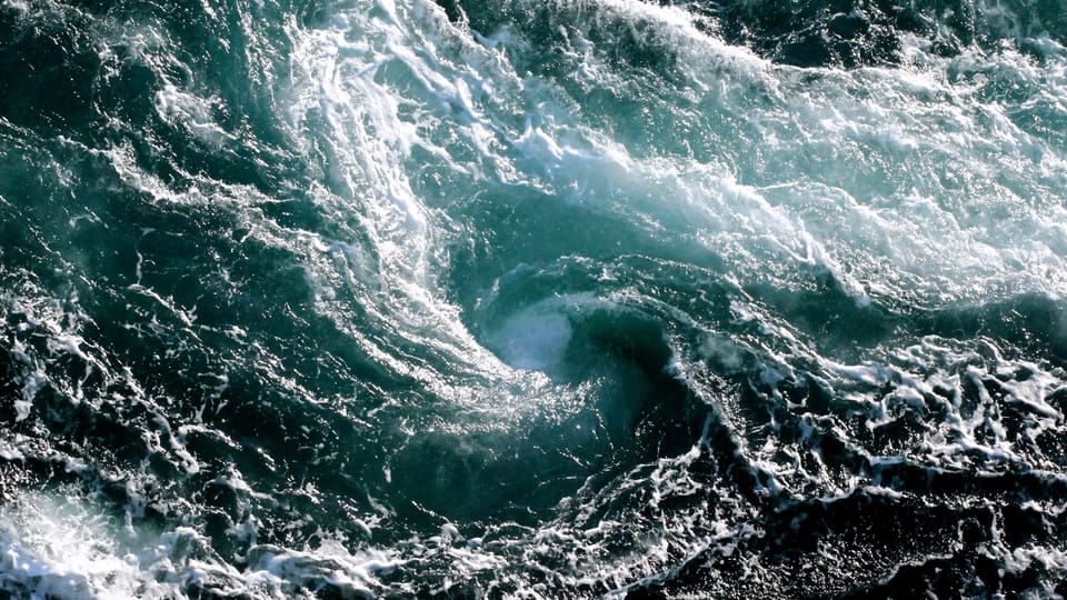 view of a tumultuous whirlpool in the sea from above